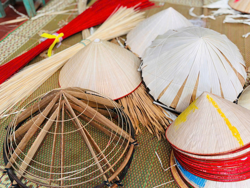 Các nghệ nhân vẫn tỉ mỉ làm thủ công từng khâu, từ đan lá đến trang trí nón. Ảnh: Nhật Chi