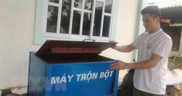 Nguyễn Văn Nhị bên máy trộn bột làm thức ăn cho gà. (Ảnh: Võ Dung/TTXVN)