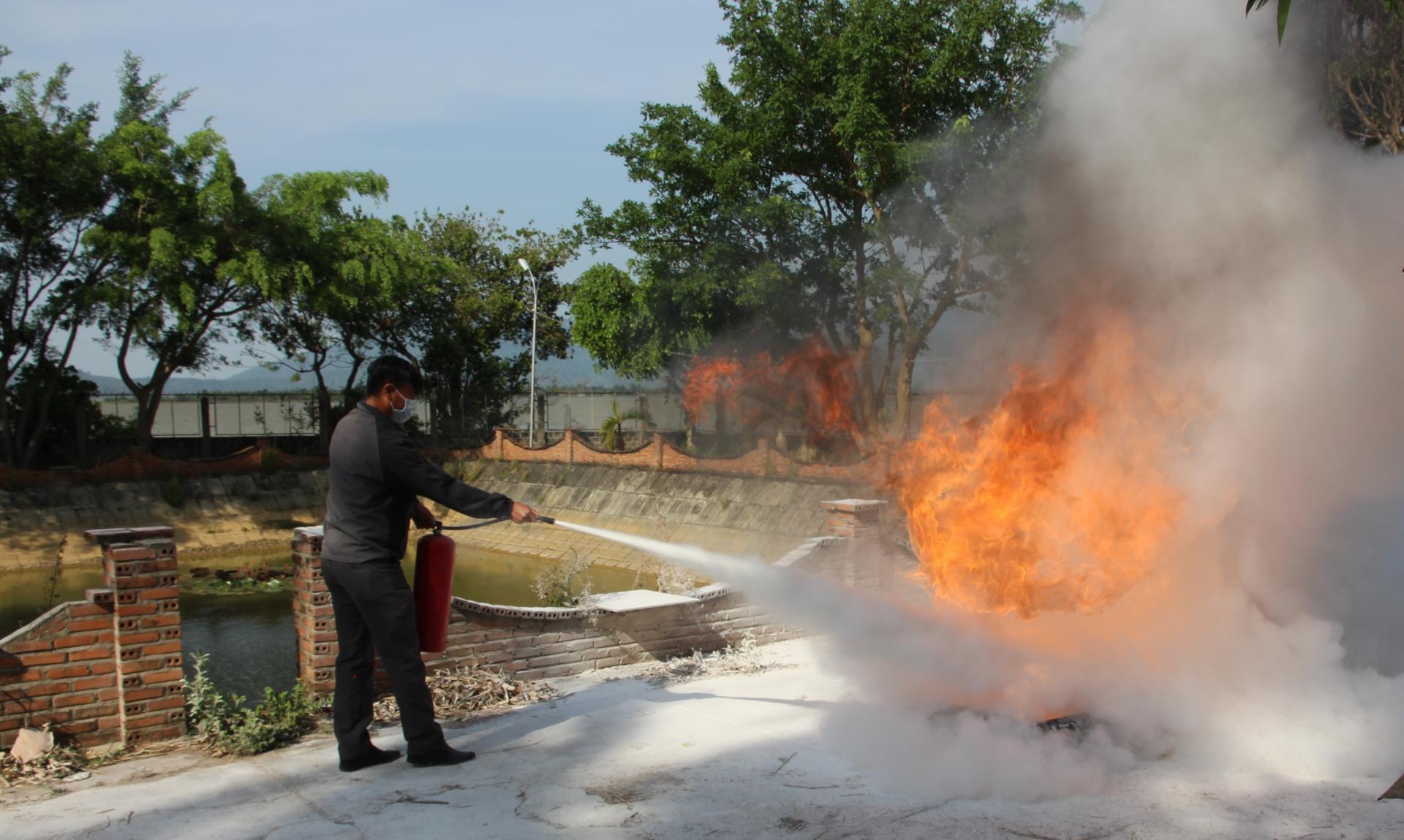 Học viên thực hành thao tác sử dụng bình bột dập tắt khay xăng đang cháy.