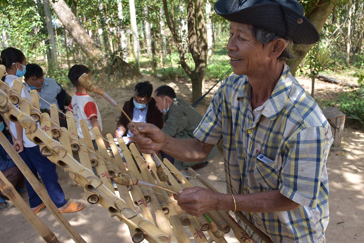 Ông Byơh (làng Bok Ayơl, xã Hà Ra) biểu diễn đàn trưng do chính mình chế tác. Ảnh: Hà Phương