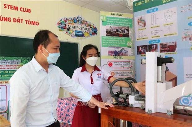 Em Vi Thị Thu Hà giới thiệu máy hút dịch chanh dây bán tự động. Ảnh: Tuấn Anh-TTXVN