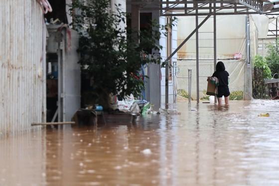 Người dân di chuyển qua khu vực ngập sâu trong nước chiều 17-5. Ảnh: ĐOÀN KIÊN