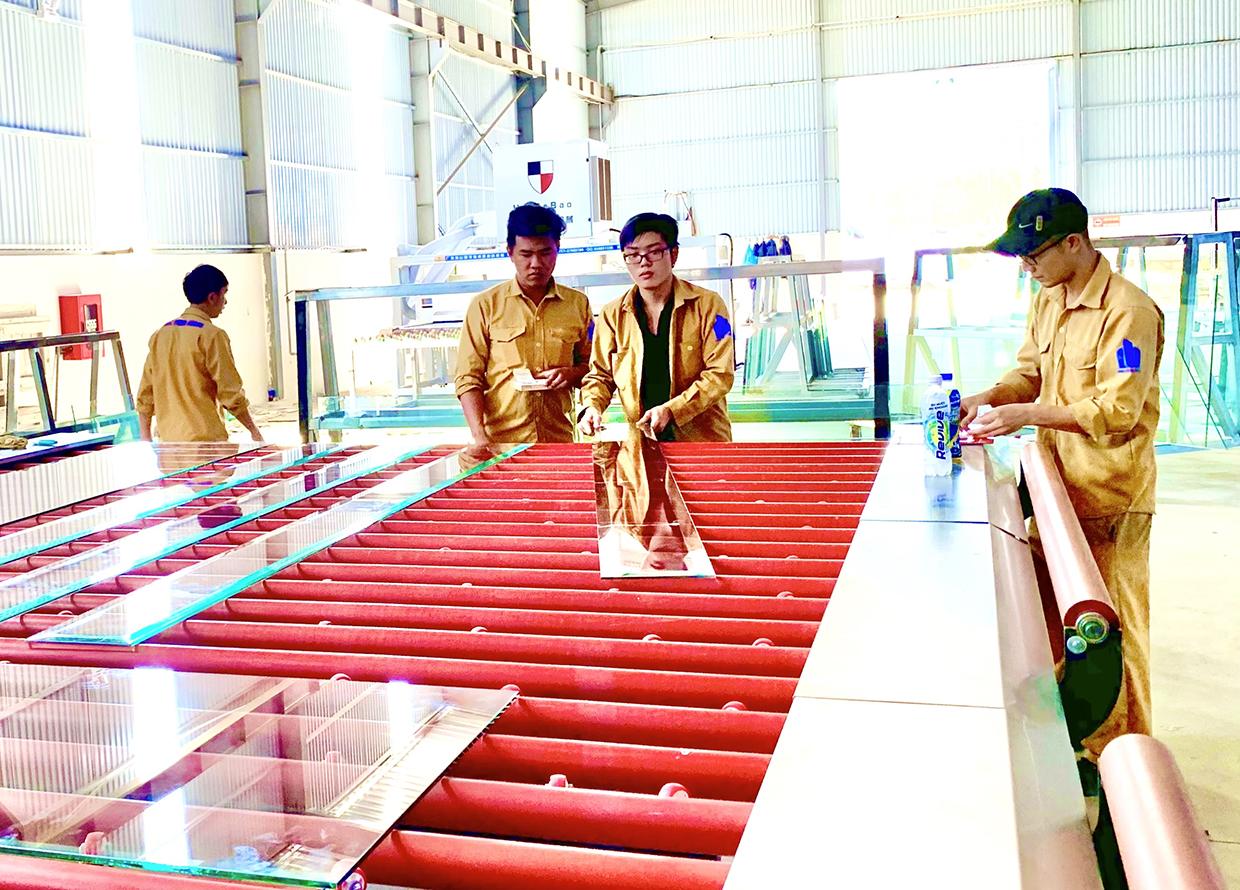 Công nhân làm việc tại Nhà máy sản xuất kính cường lực Phúc Thịnh Hoàng (Khu Công nghiệp Trà Đa, TP. Pleiku). Ảnh: Hà Duy