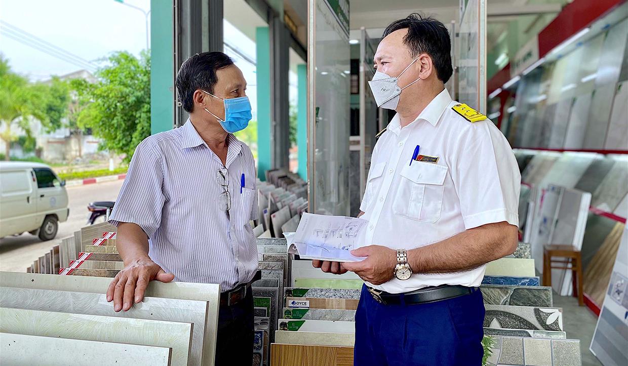 Cán bộ Đội quản lý thuế liên xã số 1 tuyên truyền các chính sách thuế cho người dân phường An Phú, thị xã An Khê. Ảnh: Mộc Trà