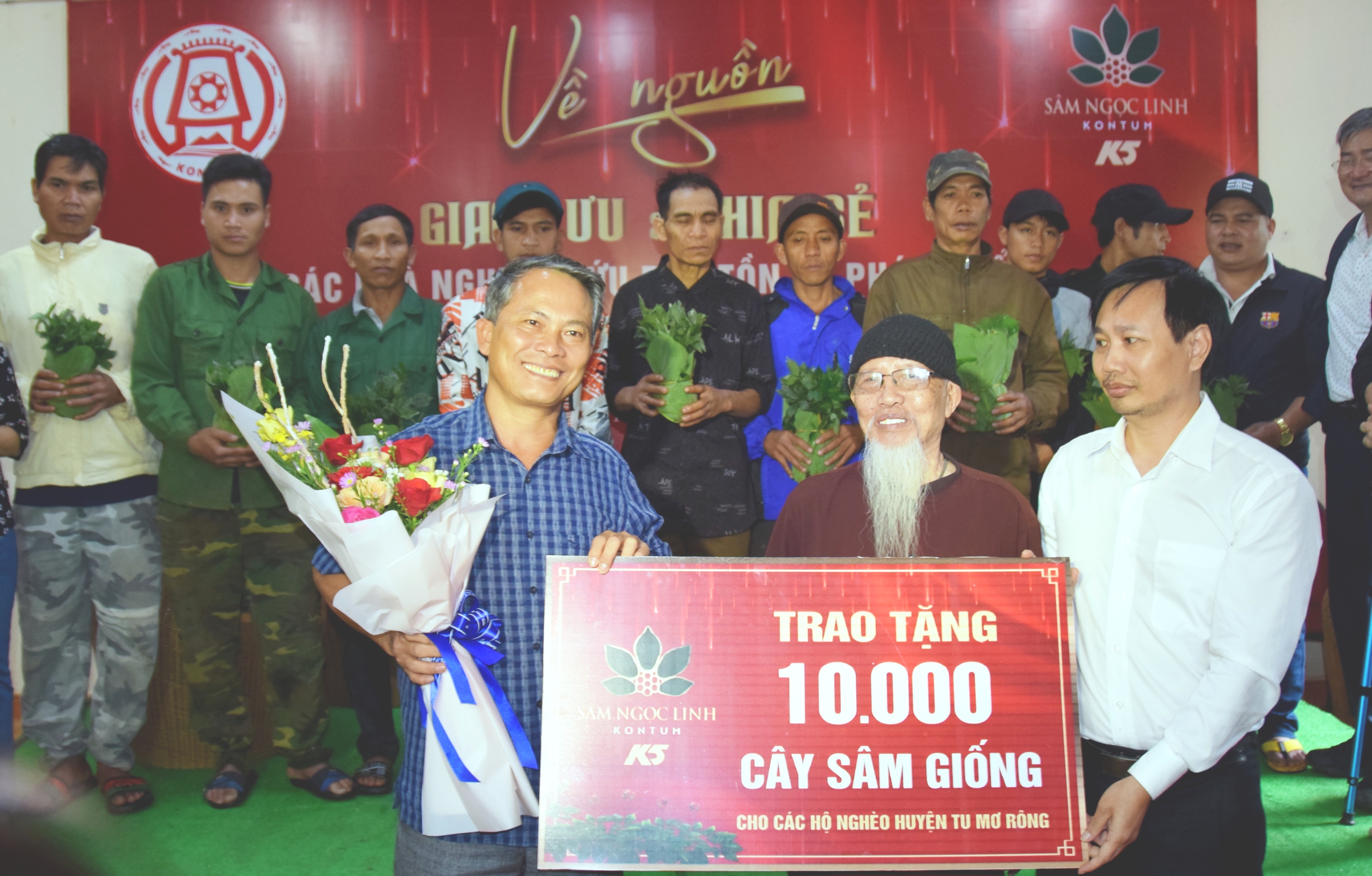 Đại diện Công ty Cổ phần Sâm Ngọc Linh Kon Tum (bên phải) trao cây sâm giống cho đại diện UBND huyện Tu Mơ Rông. Ảnh: HL