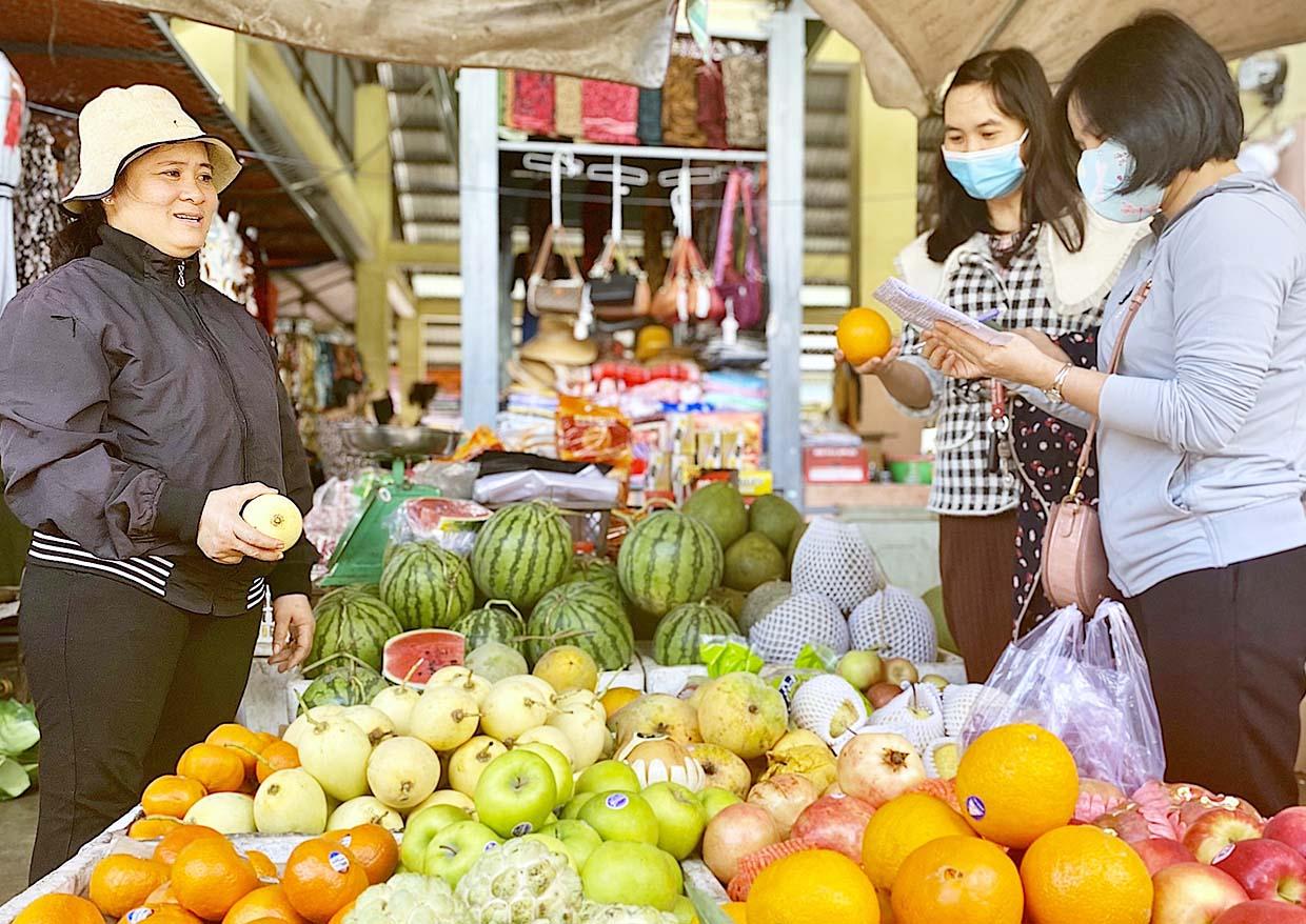 Nhân viên Bưu điện tỉnh và Cục Thống kê tỉnh (bìa phải) tiến hành điều tra giá tiêu dùng kỳ 3 tháng 10 tại chợ Hoa Lư (TP. Pleiku). Ảnh: Mộc Trà