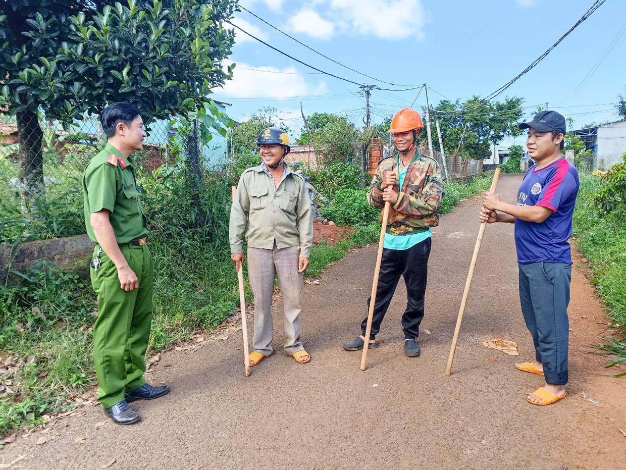 Cán bộ Công an xã Ia Pết trao đổi công việc với các thành viên Tổ tự quản an ninh trật tự thôn 10. Ảnh: R'Ô HOK