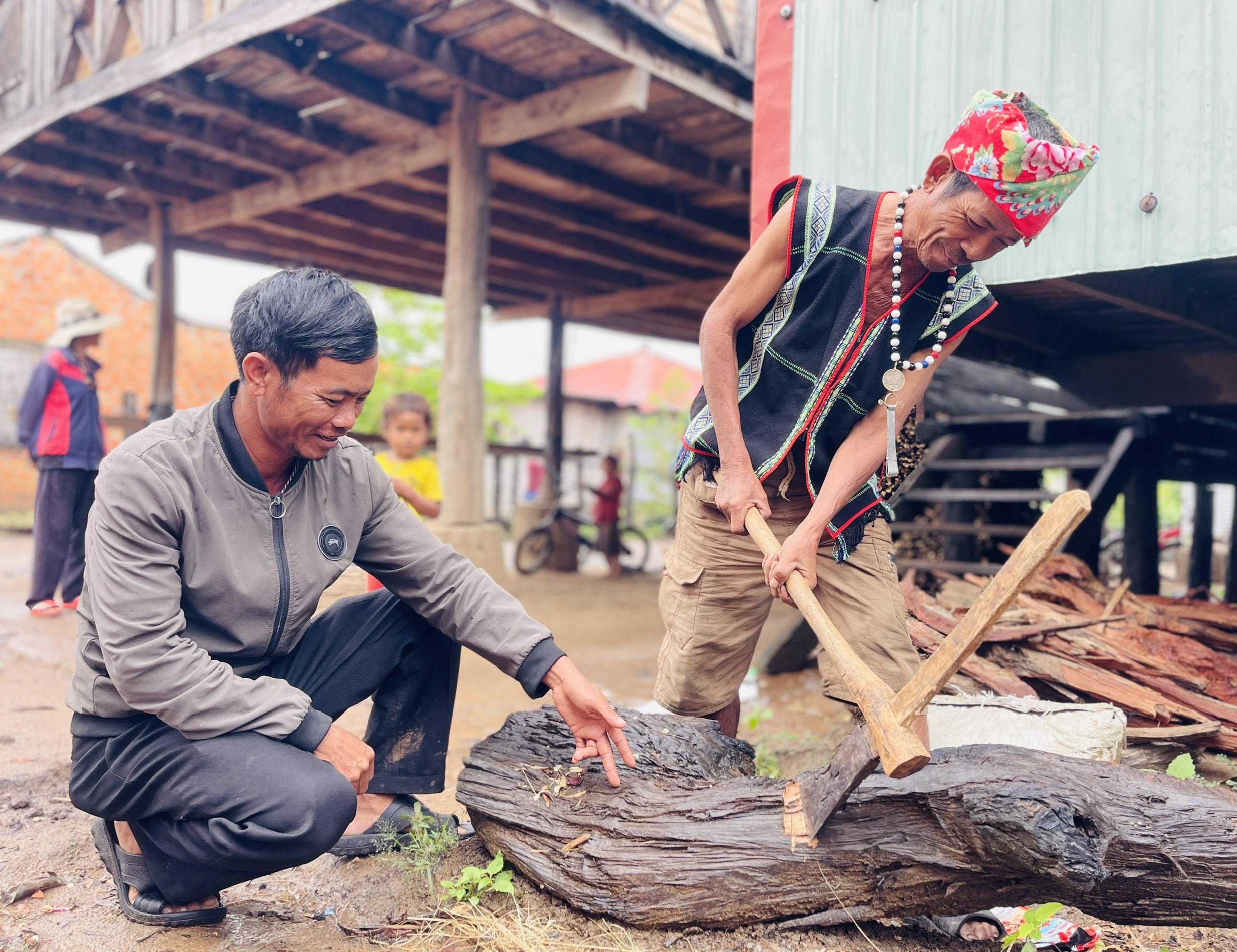 Bí thư Chi bộ kiêm Trưởng thôn Pyang Đinh Văn Drênh (trái ảnh) trao đổi với nghệ nhân Đinh Bri  về việc truyền dạy nghề tạc tượng cho lớp trẻ. Ảnh: Trần Dung