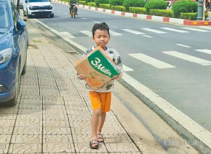 Một em nhỏ mang theo thùng mì tôm tới điểm quyên góp để ủng hộ cho các bạn miền Trung. Ảnh: Lê Sơn