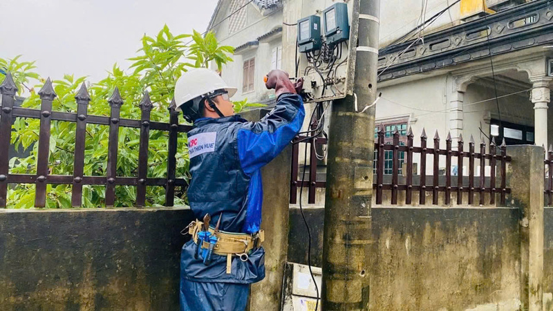 Mặc dù trời đang mưa gió, nhưng anh Đoàn kịp thời sửa chữa để cung cấp điện cho người dân. Ảnh: D. Huyền