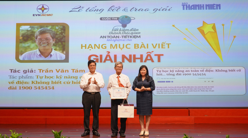 Bà Nguyễn Thị Kim Ngọc - Phó Giám đốc Sở Công Thương TP. Hồ Chí Minh và ông Võ Quang Lâm - Phó Tổng giám đốc Tập đoàn Điện lực Việt Nam, trao giải Nhất cho tác giải Trần Văn Tám. Ảnh: Minh Khuê.