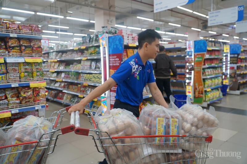 Nhân viên siêu thị tiếp thêm trứng các loại lên kệ hàng