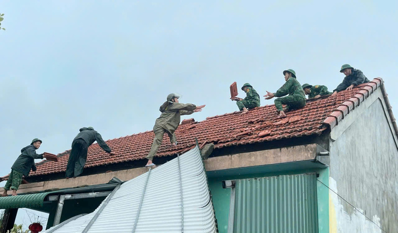 Cán bộ, chiến sĩ Đồn biên phòng Phong Hải giúp người dân lợp lái nhà. Ảnh: Nguyễn Tuấn