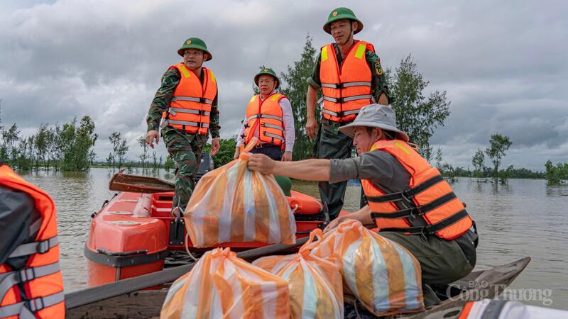 Lực lượng chức năng hỗ trợ các nhu yếu phẩm cho bà con vùng lũ.