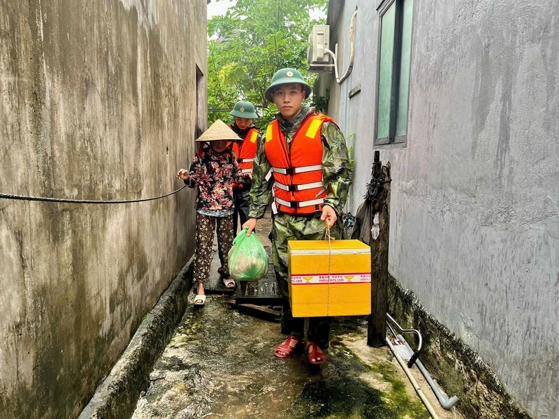 Cán bộ Đồn biên phòng Nhơn Châu hỗ trợ người dân tới nơi an toàn.
