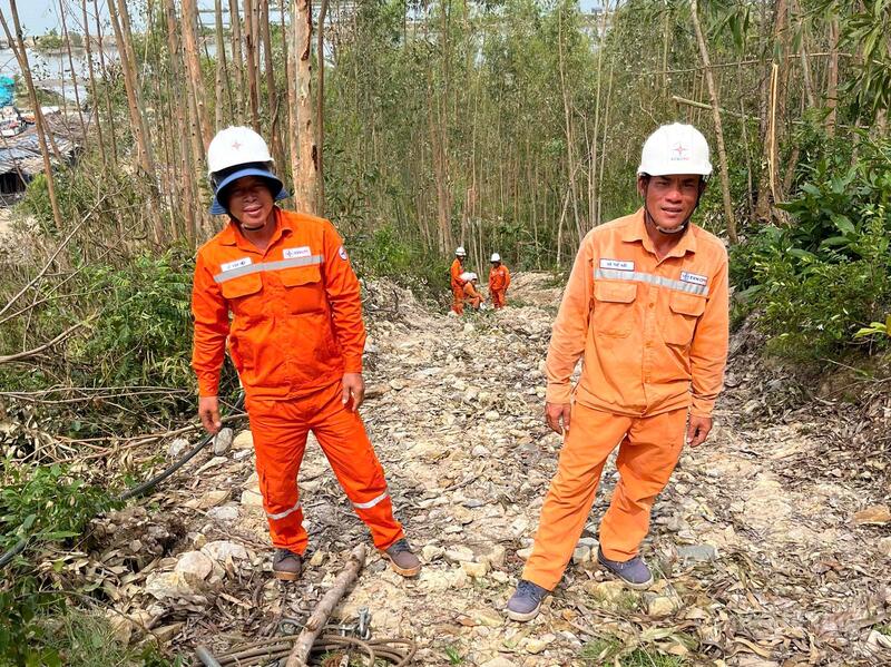 Ông Hà Thế Hải (bên phải), thuộc Đội quản lý điện Bắc Buôn Ma Thuột tham gia khắc phục cơn bão số 13 vừa qua