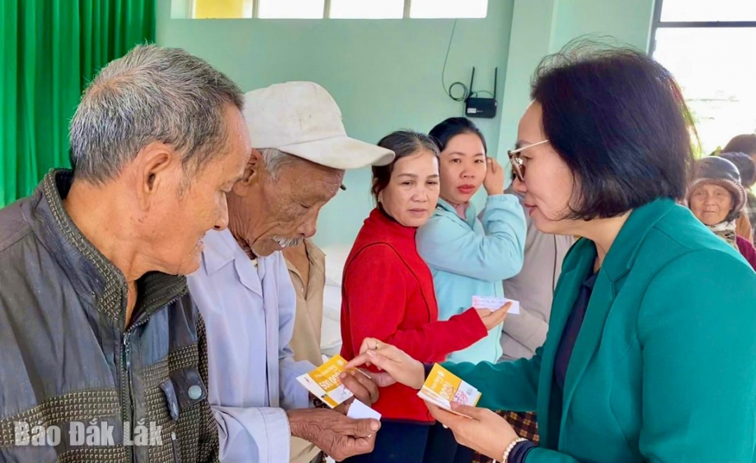 Chủ tịch Hội LHPN tỉnh Nguyễn Thị Hồng Thái trao phiếu mua hàng miễn phí cho người dân bị ảnh hưởng bởi mưa lũ.