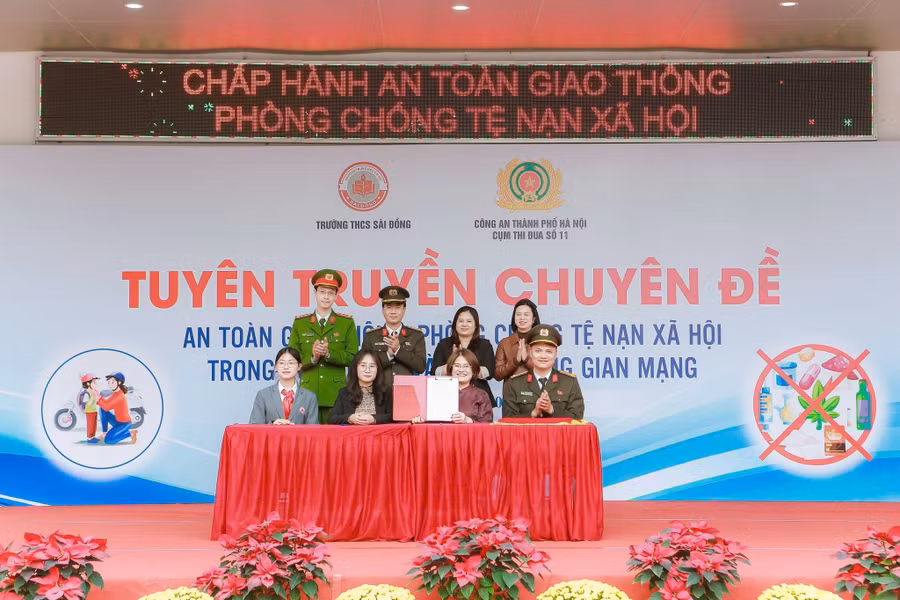 Đại diện Công an Thành phố, nhà trường, phụ huynh và học sinh cùng ký cam kết tuân thủ pháp luật. sai-dong-2.jpg