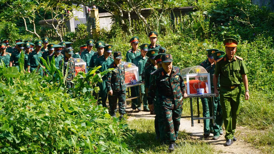 Lực lượng chức năng thực hiện di chuyển hài cốt liệt sĩ.